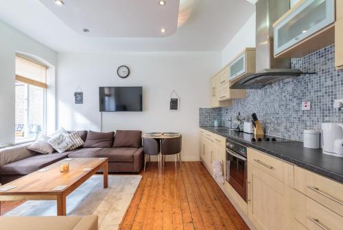 a kitchen and living room with a couch and a table at Luxury Central Newcastle Apartment 20 in Newcastle upon Tyne