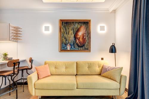 a living room with a couch and a painting on the wall at HaPPy Inn Presidential, Self check-in, Parking in the underground garage in Vilnius