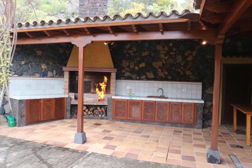 an outdoor kitchen with a fireplace in a patio at Casa Magic in Breña Baja