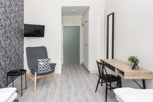 a room with a desk and chairs and a table at Hotelli Rakuuna in Lappeenranta