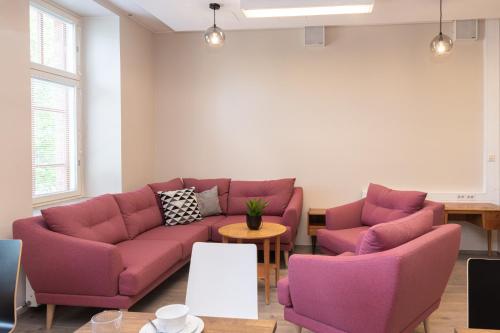 a living room with purple couches and a table at Hotelli Rakuuna in Lappeenranta