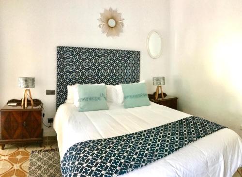 1 dormitorio con 1 cama grande con sábanas azules y blancas en La Villa Suite Málaga, en Málaga