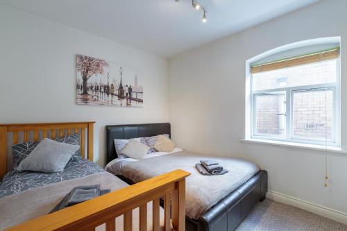 a bedroom with two beds and a window at Luxury Central Newcastle Apartment 20 in Newcastle upon Tyne