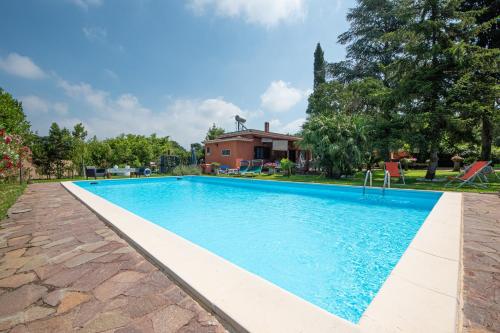 una piscina en un patio con una casa en Poggio degli Oleandri, en Nettuno