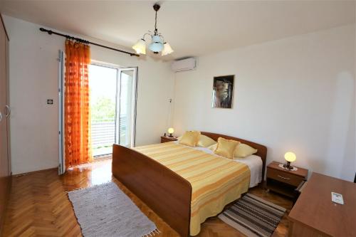 Un dormitorio con una cama y una ventana grande. en Apartmani Vinko, en Baška Voda