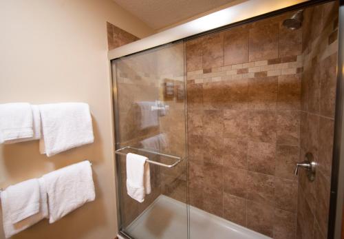 a shower with a glass door in a bathroom at Okemo Mountain Lodging in Ludlow