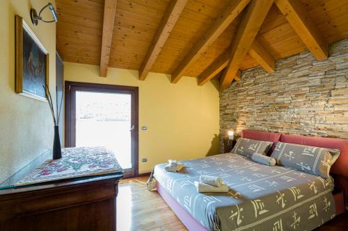 a bedroom with a bed and a brick wall at Sentirsi a Casa in Boario Terme