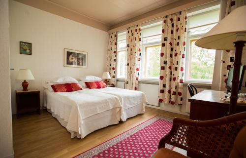 a bedroom with a white bed with red pillows at Villa Helleranta in Ulvila