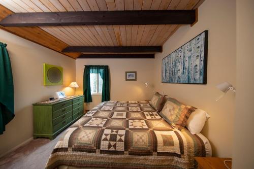 a bedroom with a bed and a wooden ceiling at Okemo Mountain Lodging in Ludlow