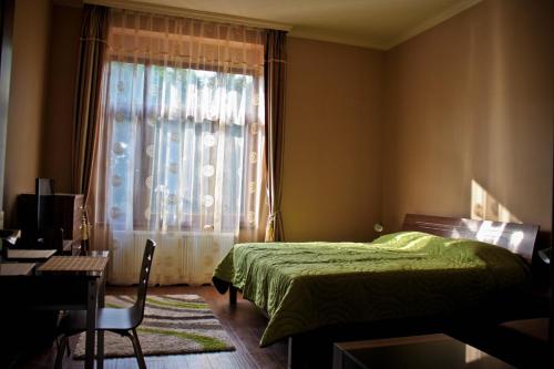 a bedroom with a green bed and a window at Spirit Apartman in Hajd&uacute;szoboszl&oacute;