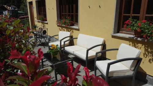 a group of chairs sitting on a patio with flowers at B&B Lo Slittone in Abetone