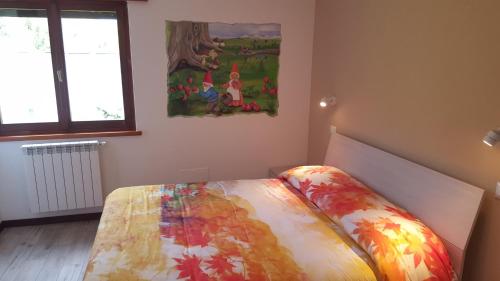 a bed in a room with a painting on the wall at B&B Lo Slittone in Abetone