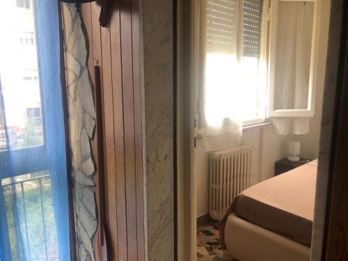 リド・ディ・カマイオーレにあるVilla Sophia Mare 1の窓付きの窓の横にベッドが備わるベッドルーム1室