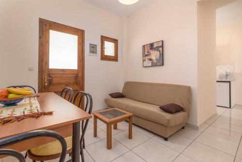 a living room with a couch and a table at Andreas Apartments in Agios Georgios Pagon