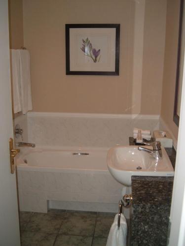a bathroom with a bath tub and a sink at Garden Court Morningside Sandton in Johannesburg