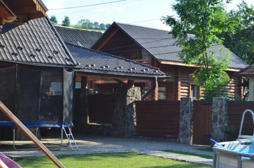 ein Haus mit einem Gamer-Dach und einer Garage in der Unterkunft Sadyba Pikuy in Belasovitsa