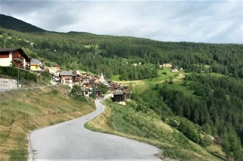 uma estrada sinuosa ao lado de uma montanha em La Chaumière d'Hérens em Vernamiège