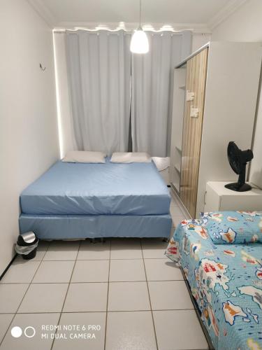 um quarto com uma cama azul, uma cama e um espelho em Porto das Dunas em Aquiraz