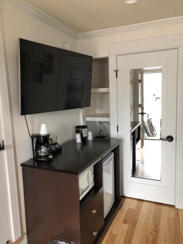a kitchen with a black counter with a tv on the wall at El Rancho Motel in Williams