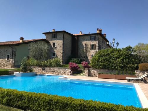 uma villa com piscina em frente a um edifício em Agriturismo Macesina em bedizzole