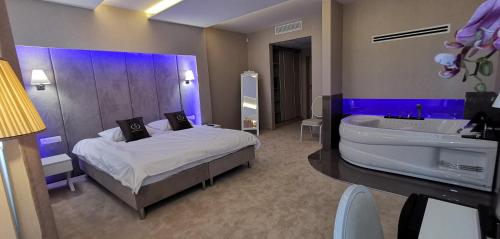 Łęczeszyce的住宿－Hotel Sevilla Gold，一间带浴缸、床和水槽的卧室