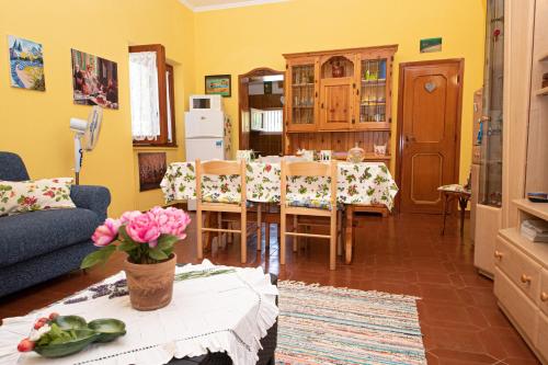 a living room with a table and chairs and a kitchen at Poggio degli Oleandri in Nettuno