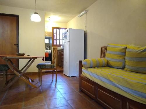 a living room with a couch and a table and a refrigerator at Cabañas La Belen in Merlo