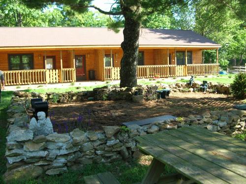 eine Blockhütte mit einer Steinmauer davor in der Unterkunft Bent Mountain Lodge in Roanoke