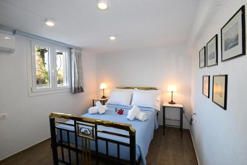 ein Schlafzimmer mit einem Bett mit weißer Bettwäsche und zwei Lampen in der Unterkunft MELISSANTHI FARM HOUSE-THYMARI in Vári
