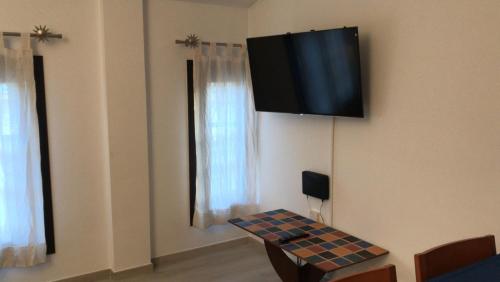 Habitación con mesa y TV en la pared. en Apartament L'Alba 2, en Tossa de Mar