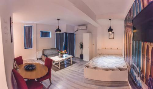 ein Wohnzimmer mit einem Bett und einem Tisch in der Unterkunft Teodoroiu nr. 5 in Craiova
