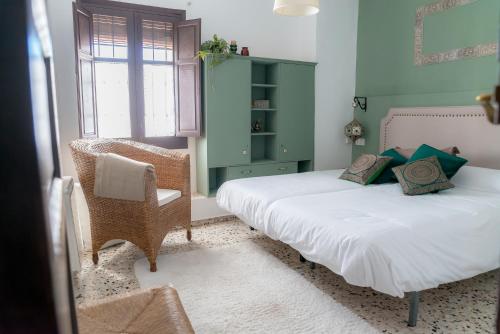 a bedroom with two beds and a chair in it at BENDITA CASA in Granada