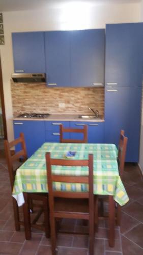 a kitchen with a table and chairs and blue cabinets at Case Susinna in Capaci