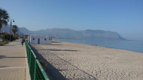a person walking on a beach next to the water at Case Susinna in Capaci