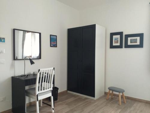 a bedroom with a black cabinet and a chair and a desk at B&B Marsà in Marzamemi