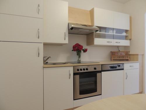 a kitchen with white cabinets and a vase of flowers at Häus`l am Ruan in Berwang