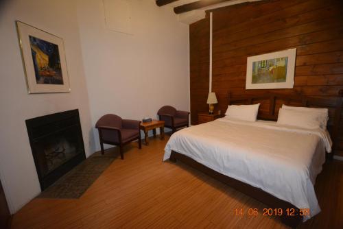 - une chambre avec un grand lit et une cheminée dans l'établissement Auberge Alpine Inn, à Sainte-Adèle