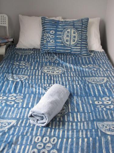 a bed with blue and white sheets and a towel on it at Apartament Baltic in Sztutowo