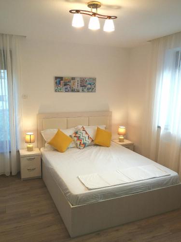 a bedroom with a bed with yellow pillows at Casa Maria Mamaia Nord in Mamaia Sat/Năvodari