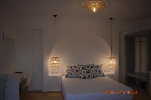 a bedroom with a bed with two lights on it at Infinity Apartments in Naxos Chora