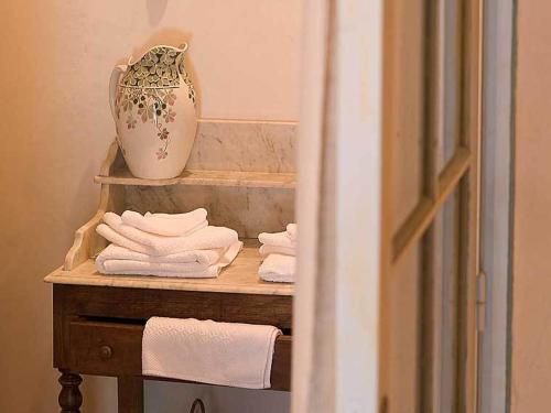 a shelf with towels and a vase on it at Hôtel De La Beursaudiere in Nitry