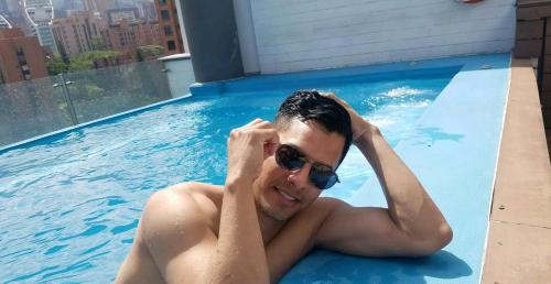 a man in a swimming pool wearing sunglasses at INN LEATHER GUEST HOUSE-GAY MALE ONLY in Fort Lauderdale