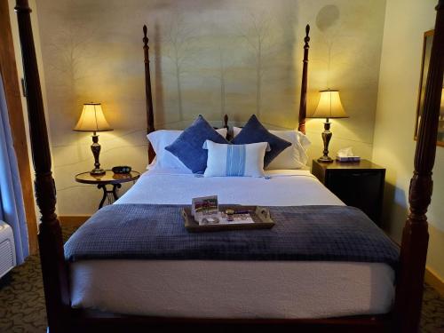 a bedroom with a large bed with blue pillows at The Barn Inn Bed and Breakfast in Millersburg