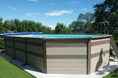 a pool deck with a swimming pool in a backyard at Maison d'Hôte la Grange aux Ayres in Olloix