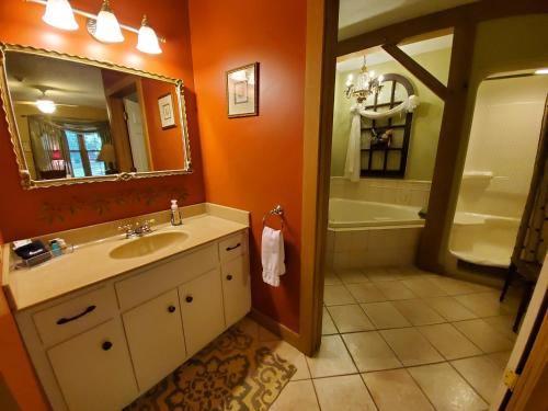 a bathroom with a sink and a mirror and a tub at The Barn Inn Bed and Breakfast in Millersburg