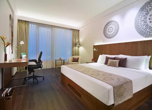 a hotel room with a bed and a desk at Vivanta Chennai IT Expressway OMR in Chennai