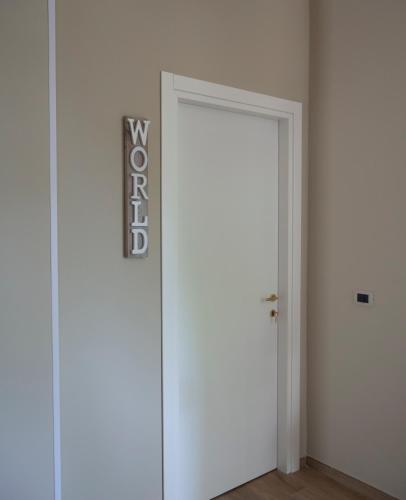 a white door with a sign on it in a room at Viaggio in Sicilia B&B in Gravina di Catania