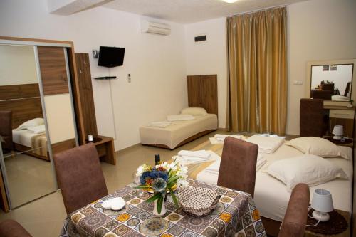 a hotel room with a table and two beds at Villa Andjelina in Budva