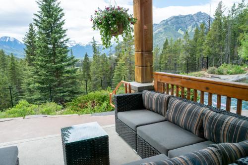 a couch on a porch with a view of mountains at The Hidden Ridge Resort in Banff