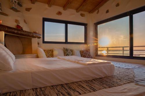 a bedroom with a bed with a view of the ocean at Apágkio Filoxenia in Archangelos